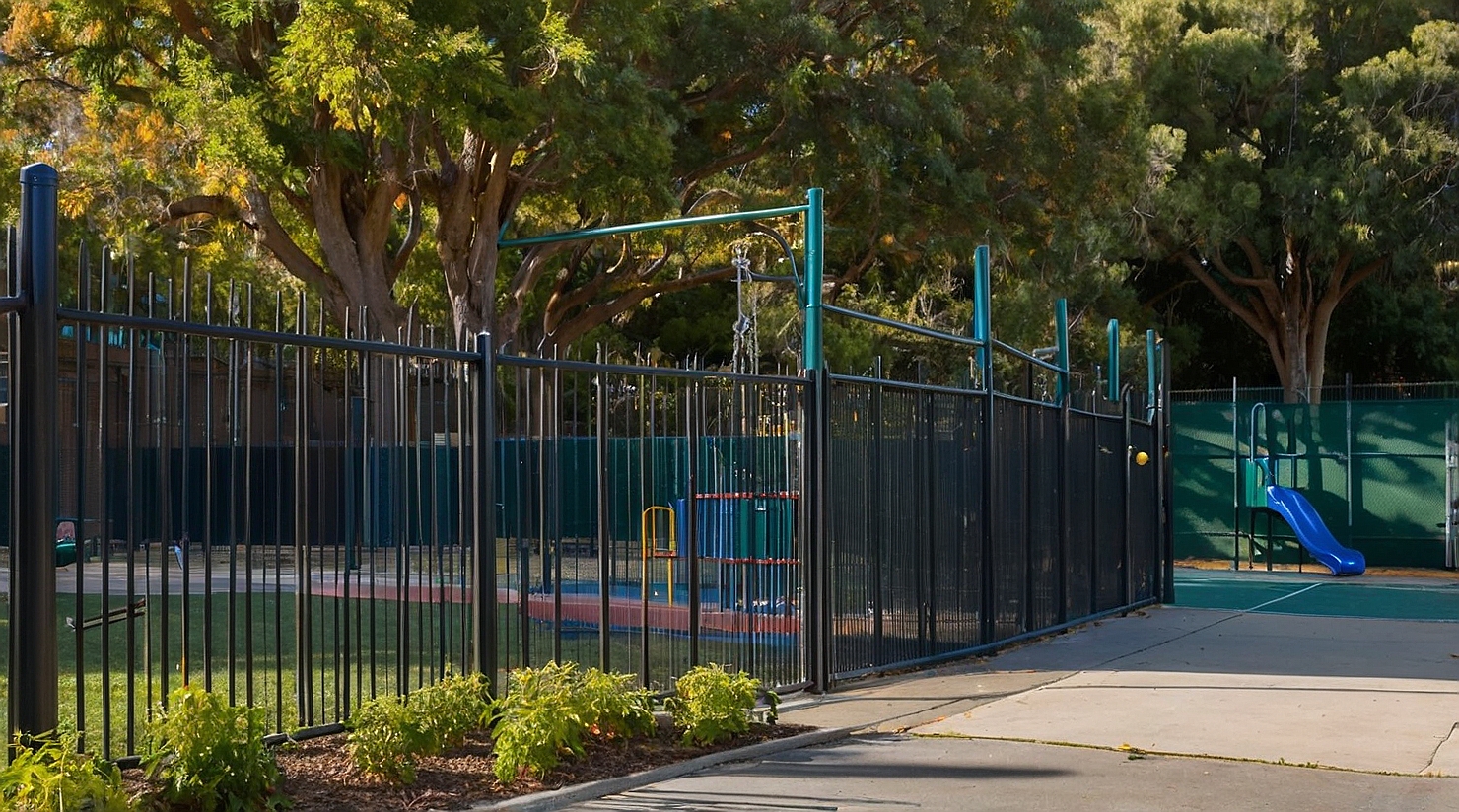 Modern aluminum fence installed around a high school campus entrance